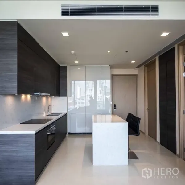Condominium for rent in Watthana, Bangkok - Sleek open kitchen with dark cabinets, marble island and built-in appliances.