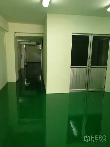 Factory for rent in Mueang Samut Sakhon, Samut Sakhon - Corridor and office entrance with green epoxy flooring and aluminum-framed door.