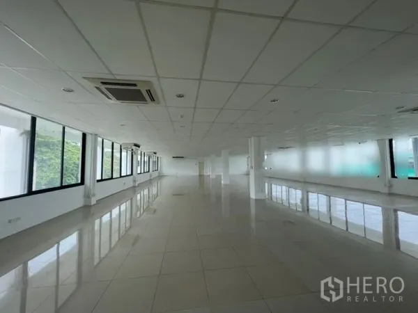 สำนักงาน ให้เช่า - โถงทำงานยาวพร้อมเครื่องปรับอากาศแบบคาสเซ็ต เสาโครงสร้าง และหน้าต่างกว้างมองเห็นพื้นที่สีเขียว