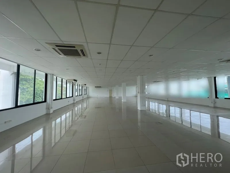 สำนักงาน ให้เช่า - โถงทำงานยาวพร้อมเครื่องปรับอากาศแบบคาสเซ็ต เสาโครงสร้าง และหน้าต่างกว้างมองเห็นพื้นที่สีเขียว