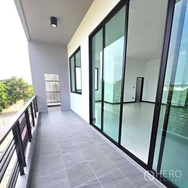 คลังสินค้า ขายในLam Luk Ka, Pathum Thani - ระเบียงชั้นบนปูพื้นกระเบื้องเทา พร้อมประตูกระจกบานเลื่อนเข้าสู่ออฟฟิศโปร่งสว่าง