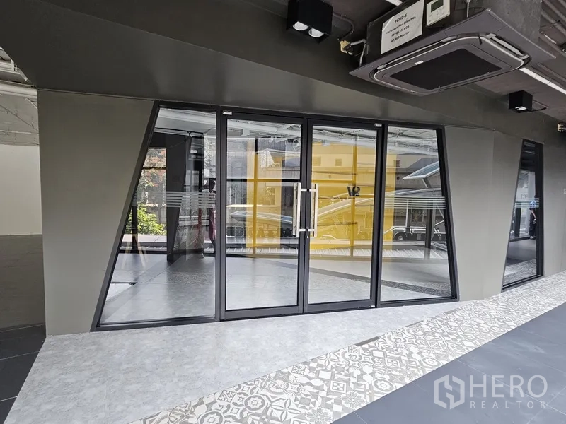 零售空间 出租 - 一层店面双扇玻璃门，门外有花纹地砖走道。