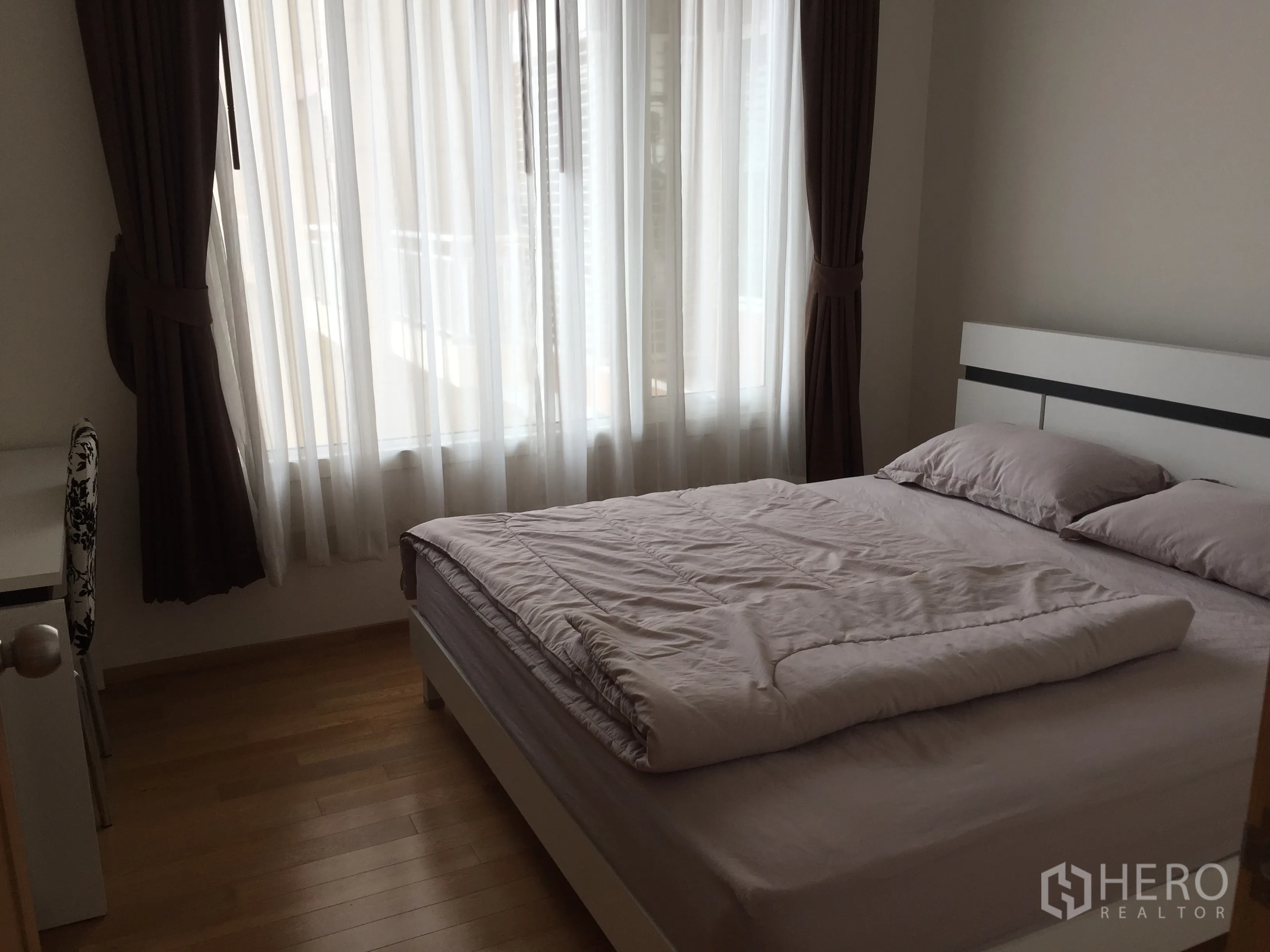 Condominium for rent in Sathon, Bangkok - Second bedroom with large window, blackout curtains, writing desk and a queen-size bed.