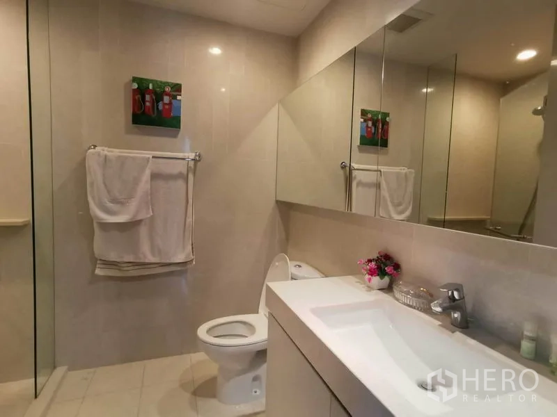 公寓 出租在Watthana, Bangkok - 客卫配玻璃淋浴间、坐便器与一体式镜面台盆。