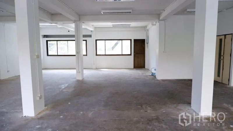 办公空间 出租在Watthana, Bangkok - 宽阔工作区，一侧整排窗户与两扇内门。