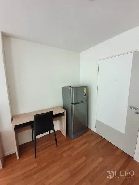 คอนโด ขายในChatuchak, Bangkok - มุมทำงานขนาดกะทัดรัด โต๊ะไม้ เก้าอี้ดำ และตู้เย็นสีเงินใกล้ประตู