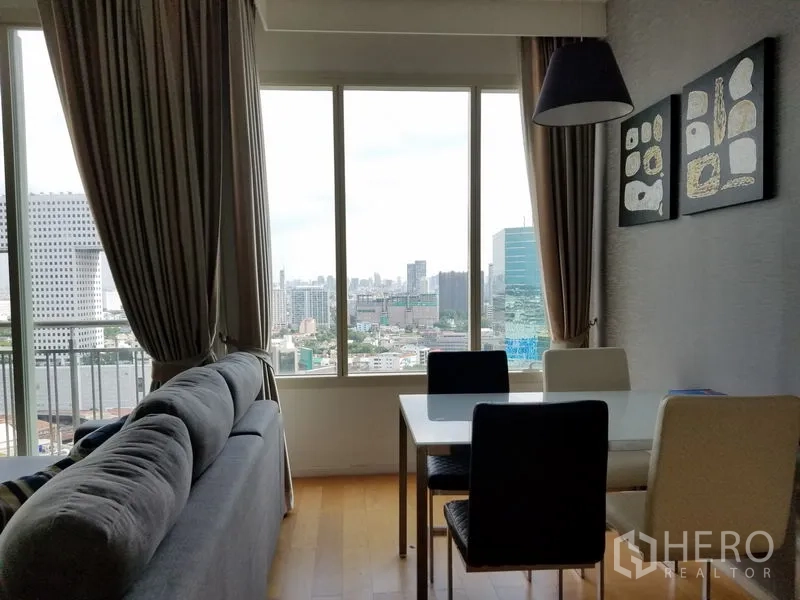 Condominium for rent in Chatuchak, Bangkok - Window‑side dining nook with a four‑seat table, pendant lamp and expansive city view.