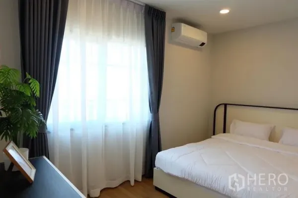 Detached House for rent in Bang Phli, Samut Prakan - Bright bedroom with double bed, air conditioner, sheer curtains and wood flooring.