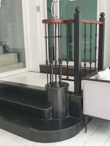 零售空间 出租在Huai Khwang, Bangkok - 大堂黑色台阶与铁艺栏杆、木扶手的近景。