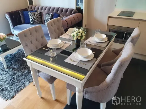 公寓 出租在Watthana, Bangkok - 四人餐桌与绒面餐椅，旁接沙发的曼谷瓦他那区一卧公寓餐厅。