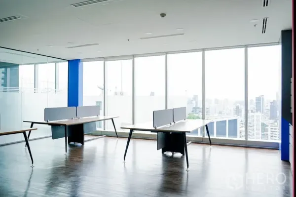 Office Space for rent in Khlong Toei, Bangkok - Bright open-plan office with floor-to-ceiling windows, wood floors, glass partition, and Bangkok skyline views.