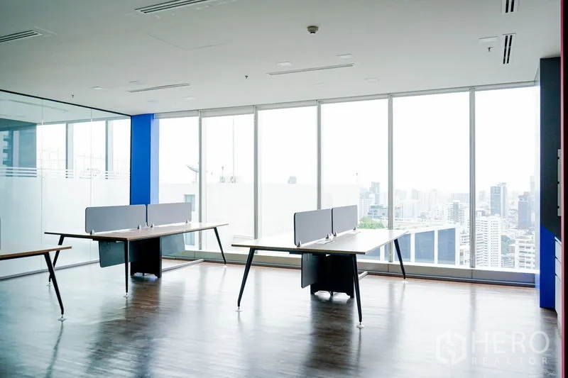 Office Space for rent in Khlong Toei, Bangkok - Bright open-plan office with floor-to-ceiling windows, wood floors, glass partition, and Bangkok skyline views.
