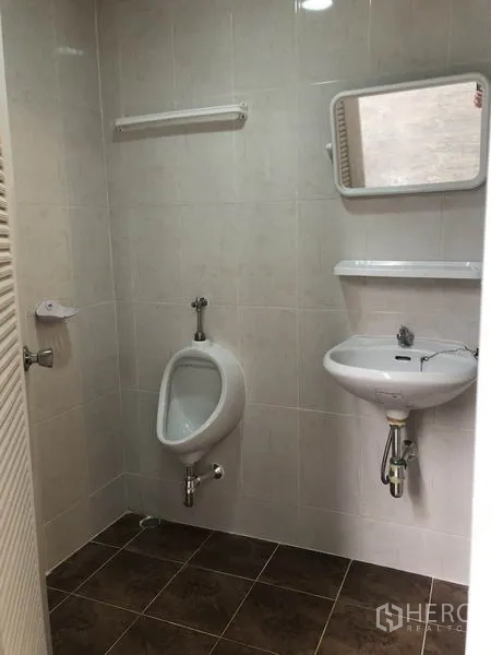 工厂 出租在Pak Kret, Nonthaburi - 工厂内瓷砖卫浴，墙挂式洗手盆与小便池。