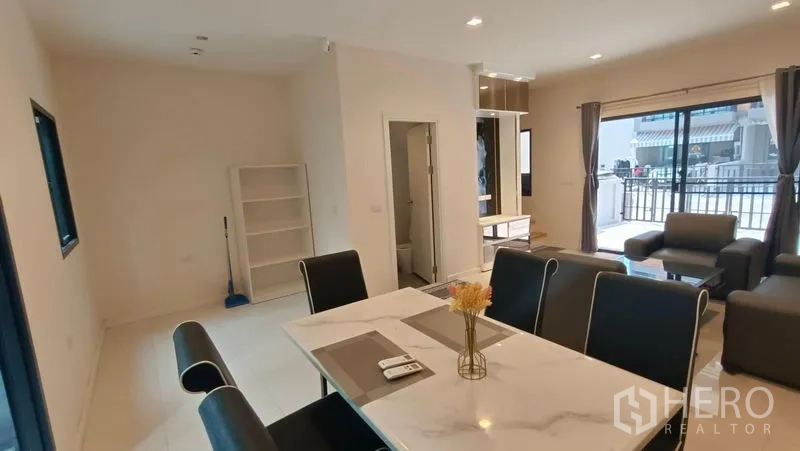 联排别墅 出租 - 开放式餐客区，岩板餐桌、前方推拉落地窗与客用卫生间。