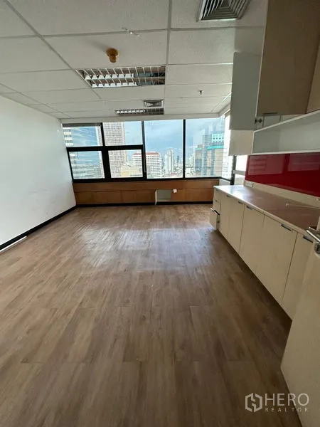 Office Space for rent in Bangkok - Private office or pantry room with wood flooring, built-in cabinets, and city views through large windows.