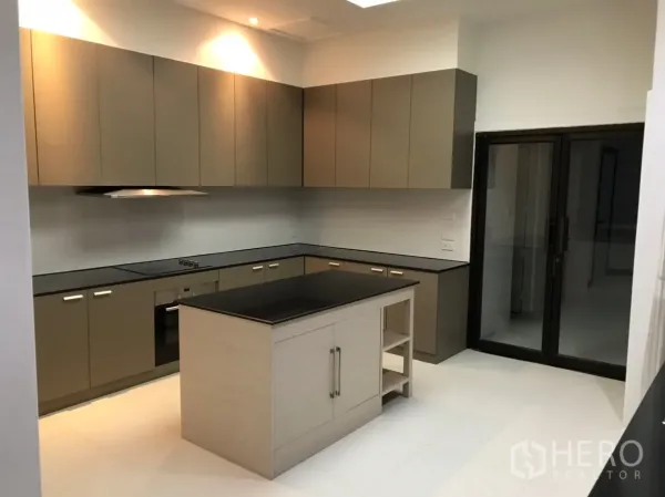 Condominium for rent in Watthana, Bangkok - Modern U-shaped kitchen with island, black stone countertops, and ample cabinets.