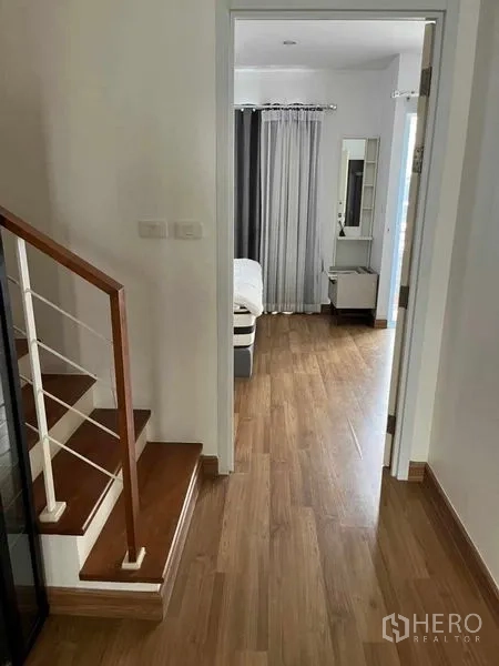 ทาวน์เฮาส์ ให้เช่าในSuan Luang, Bangkok - โถงทางเดินชั้นบนพื้นไม้ต่อเนื่องไปยังห้องนอนและบันได