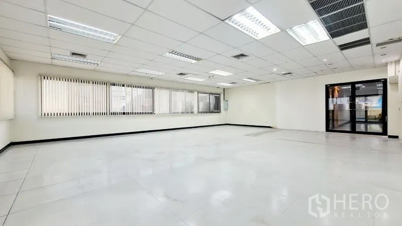 Office Space for rent in Watthana, Bangkok - Open workspace facing the entrance doors with ceiling lighting and air-return grilles.