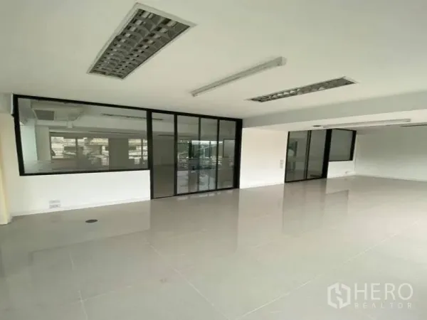 Office Space for rent in Suan Luang, Bangkok - Open office area with black-framed glass partitions and sliding doors.