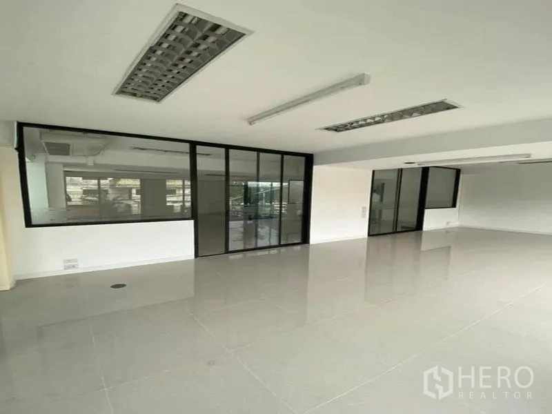Office Space for rent in Suan Luang, Bangkok - Open office area with black-framed glass partitions and sliding doors.