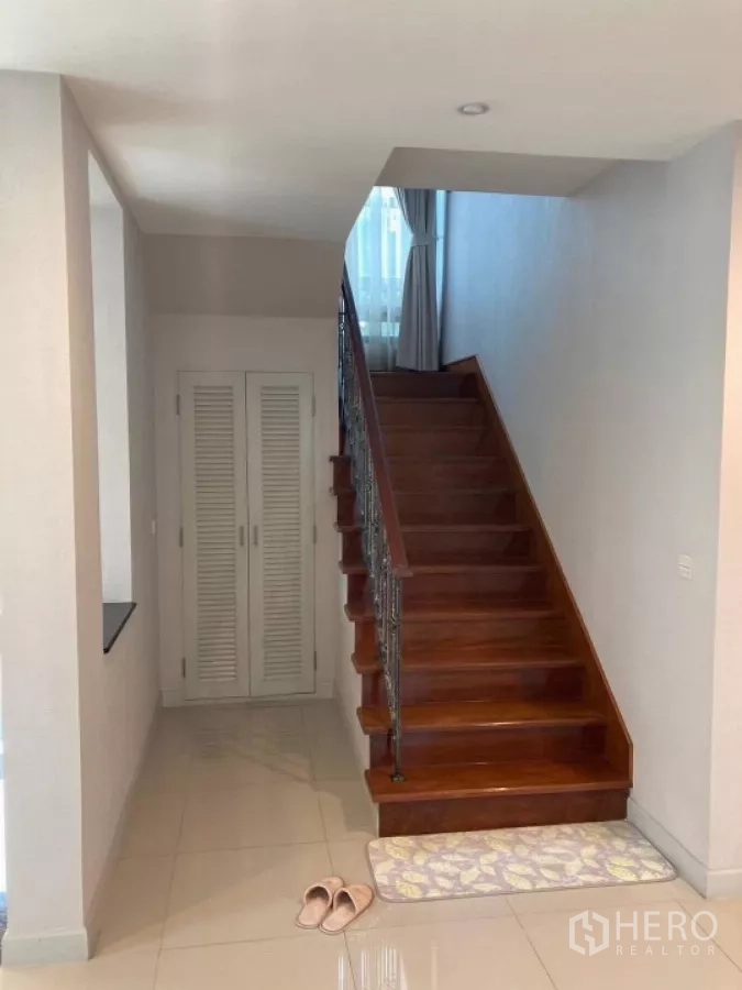 บ้าน ให้เช่าในMueang Nonthaburi, Nonthaburi - บันไดไม้มีตู้เก็บของด้านล่าง เชื่อมขึ้นสู่ชั้นสอง