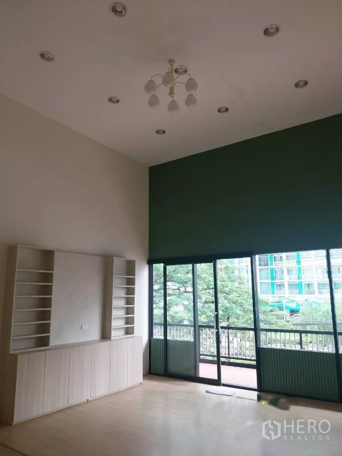 พื้นที่ขายปลีก ให้เช่า - ภายในเพดานสูง โปร่งสว่าง มีโคมไฟ ชั้นวางบิวท์อิน และประตูกระจกบานเลื่อนออกระเบียง