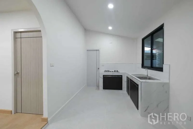 独立式住宅 出售在Bueng Kum, Bangkok - 一字型厨房，大理石纹台面，燃气灶、水槽与窗户