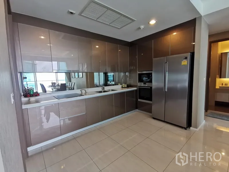Condominium for rent in Bang Kho Laem, Bangkok - Contemporary kitchen with glossy cabinetry, built-in oven and a double-door refrigerator.