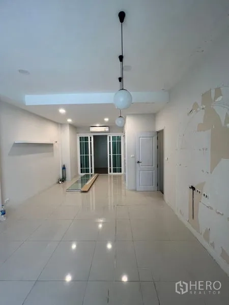 带办公室的家 出租 - 一层接待空间，亮面地砖、吊灯与玻璃推拉门。