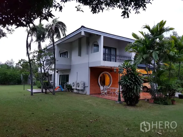 独立式住宅 出租在Khan Na Yao, Bangkok - 两层独栋别墅，带覆盖露台与圆形窗，大片草坪和热带植物，位于曼谷坎那尧。