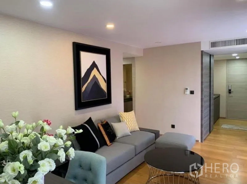 Condominium for rent or sale in Pathum Wan, Bangkok - Open-plan lounge with recessed lighting, sofa set and entry corridor inside a Bangkok condominium.