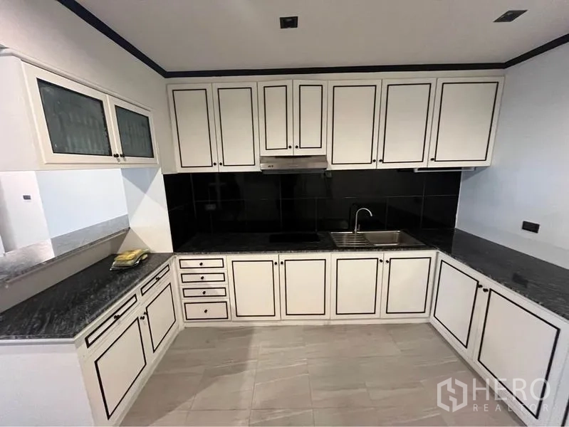 คอนโด ให้เช่าหรือขายในWatthana, Bangkok - ครัวรูปตัวยู ตู้หน้าบานขาว ผนังกระเบื้องสีดำ และท็อปหินแกรนิต