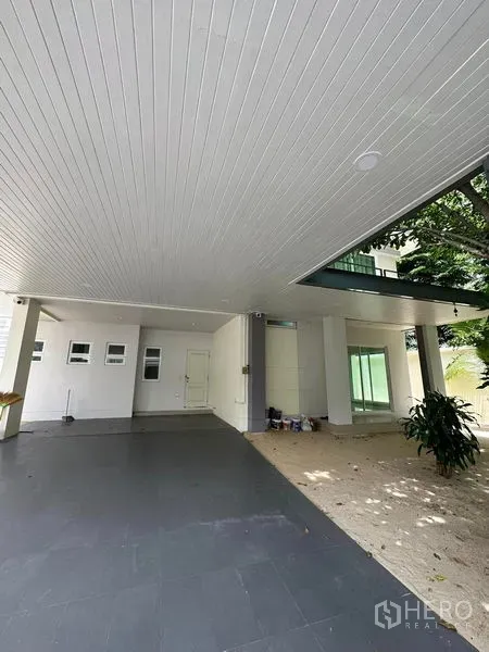 บ้าน ขายในPrawet, Bangkok - โรงจอดรถมีหลังคาขนาดใหญ่ เชื่อมเฉลียงข้างสวน ในเขตประเวศ กรุงเทพฯ