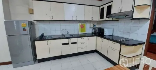 คอนโด ให้เช่าในKhlong Toei, Bangkok - ครัวรูปตัวแอล ตู้สีขาว ท็อปสีดำ เตา เครื่องดูดควัน ตู้เย็น และไมโครเวฟ