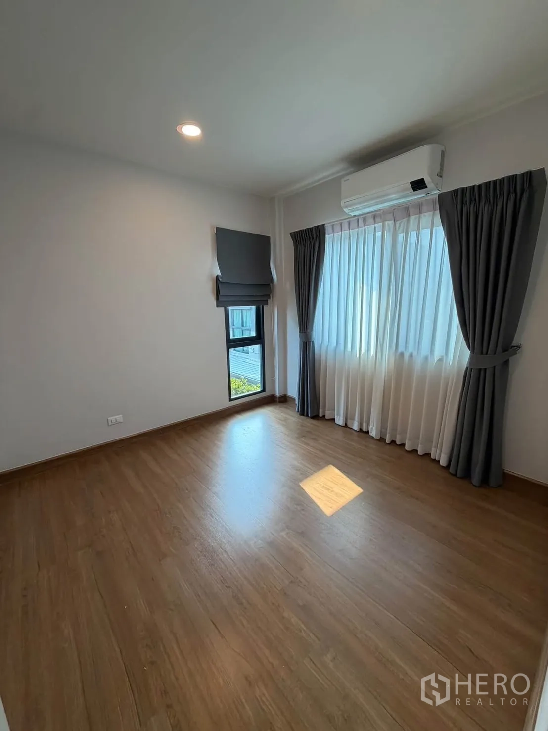 บ้านเดี่ยว for rent in Bang Phli, Samut Prakan - ห้องนอนโล่งพื้นไม้ มีเครื่องปรับอากาศและผ้าม่านเต็มบาน.