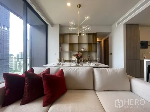 Condominium for rent in Watthana, Bangkok - View over the sofa to the dining area with modern chandelier and city outlook through sliding glass doors.