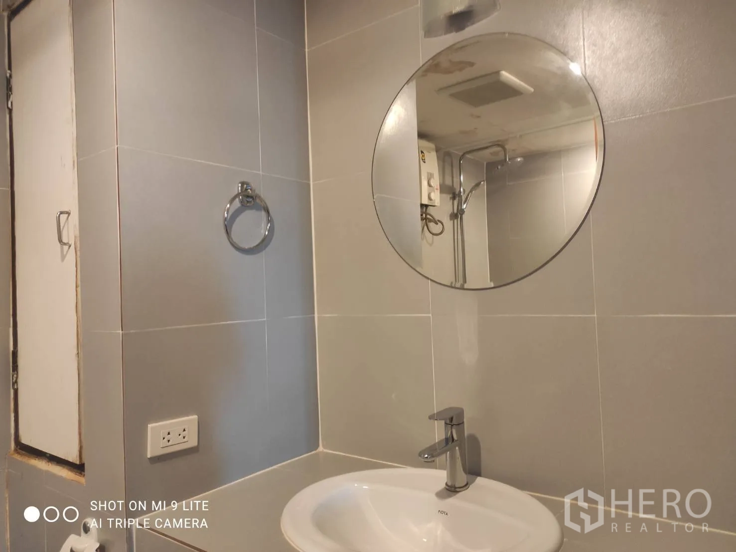อพาร์ทเมนท์ ให้เช่าในWatthana, Bangkok - ห้องน้ำกระจกเงากลม อ่างล้างหน้าเซรามิก และผนังกระเบื้องสีเทา