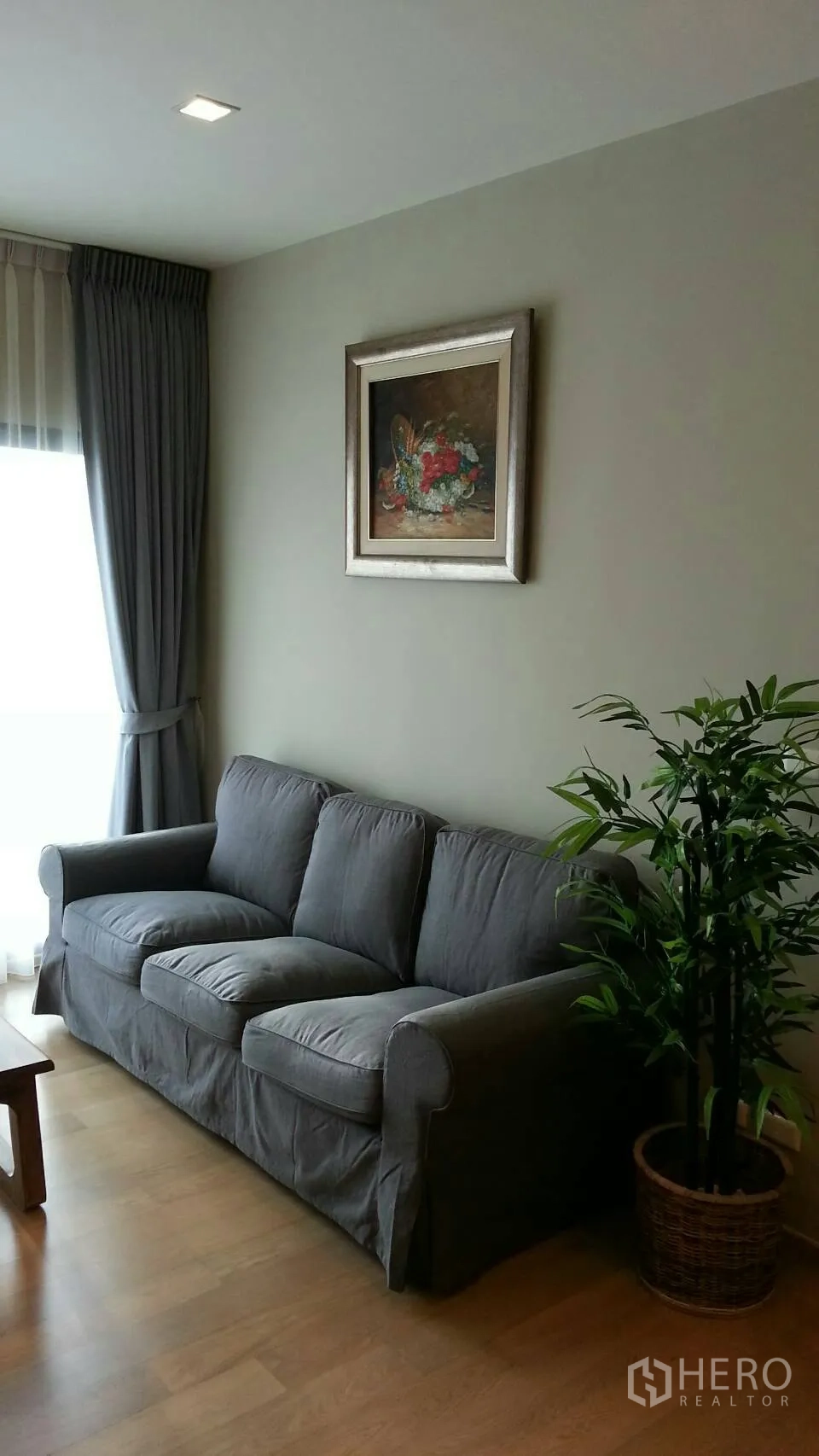 คอนโด ให้เช่าหรือขายในWatthana, Bangkok - ห้องนั่งเล่นอบอุ่น โซฟาผ้าเทา หน้าต่างบานใหญ่พร้อมผ้าม่าน และต้นไม้กระถาง