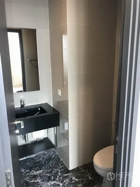 คอนโด ให้เช่าในWatthana, Bangkok - ห้องน้ำร่วมสมัยพร้อมอ่างล้างหน้าสีดำ กระจก และโถสุขภัณฑ์ พื้นลายหินอ่อน