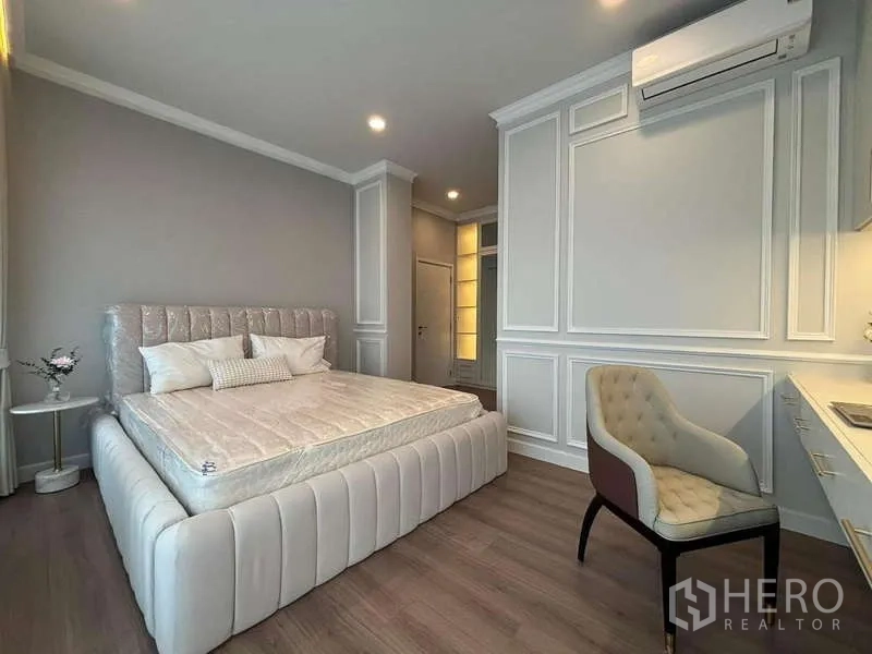 Detached House for rent in Bang Phli, Samut Prakan - Bright bedroom with upholstered bed, built-in desk and classic wall paneling.