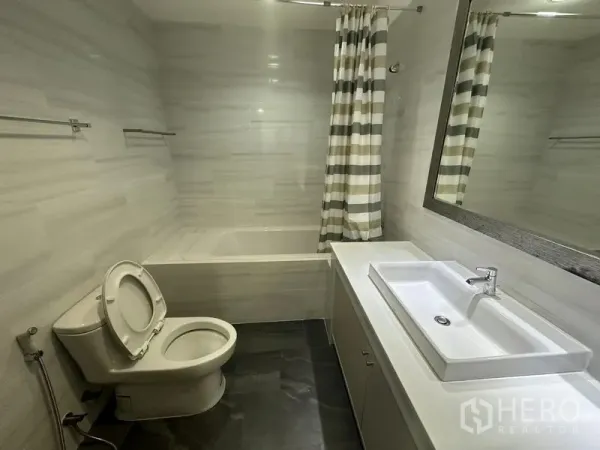 คอนโด ให้เช่าในWatthana, Bangkok - ห้องน้ำโมเดิร์นพร้อมอ่างอาบน้ำ เคาน์เตอร์ยาว และผ้าม่านลายทาง ในคอนโดใกล้ BTS พร้อมพงษ์