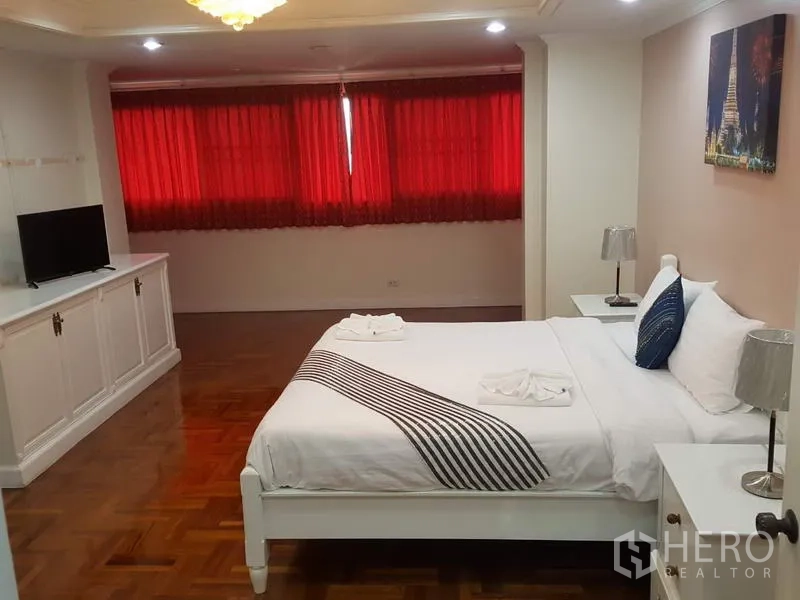 คอนโด ให้เช่าในWatthana, Bangkok - ห้องนอนกว้างขวาง เตียงสีขาว ตู้วางทีวีบิวท์อิน พื้นปาร์เกต์ และผ้าม่านสีแดง