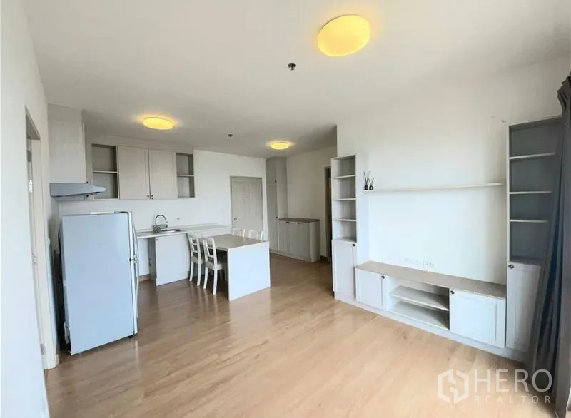 Condominium for sale - Bright open-plan living and kitchen with island, wood floors, built-in shelving and large windows.