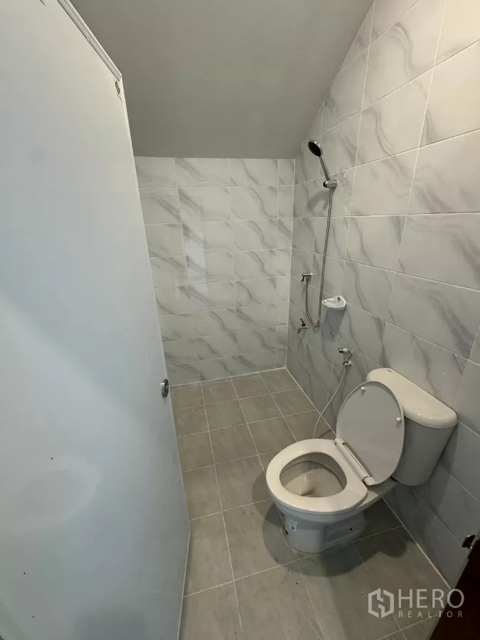 Warehouse for rent in Bang Khun Thian, Bangkok - Clean tiled bathroom fitted with a shower set and toilet.