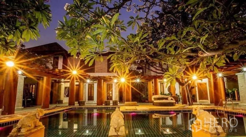 Detached House for sale in Bueng Kum, Bangkok - Evening view of pool courtyard with warm lights and sculptural details.