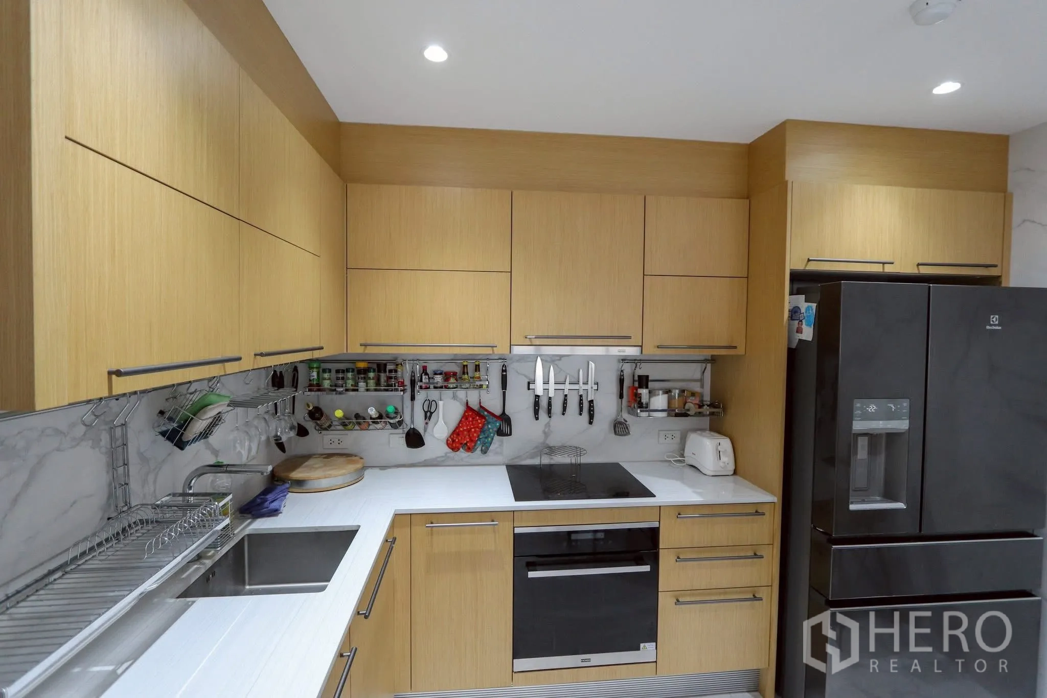 คอนโด ให้เช่าในPathum Wan, Bangkok - ครัวรูปตัวยู ตู้เก็บของเยอะ ผนังลายหินอ่อน และตู้เย็นขนาดใหญ่