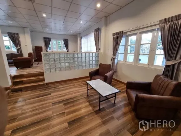 独立式住宅 出租在Mueang Nonthaburi, Nonthaburi - 错层客厅，玻璃砖隔断，木纹地砖与窗帘。