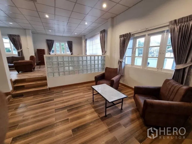 独立式住宅 出租在Mueang Nonthaburi, Nonthaburi - 错层客厅，玻璃砖隔断，木纹地砖与窗帘。