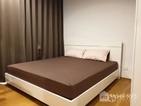 公寓 出租或出售在Bang Rak, Bangkok - 极简卧室，双人床、木地板与全遮光窗帘。