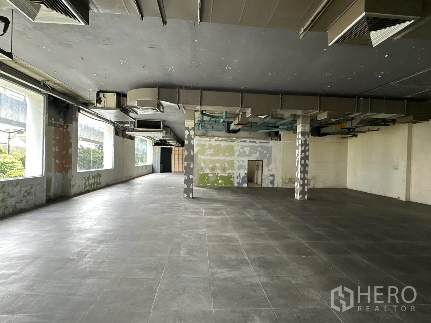 Retail Space for rent in Watthana, Bangkok - Long retail floor with large windows and HVAC ducting overhead.
